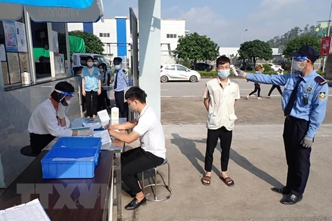 Thực hiện các biện pháp kiểm tra thân nhiệt, khử trùng, khai báo y tế… đối với người lao động tại Khu công nghiệp Điềm Thụy, huyện Phú Bình, tỉnh Thái Nguyên, ngày 14/5/2021. (Ảnh: Anh Tuấn/TTXVN)