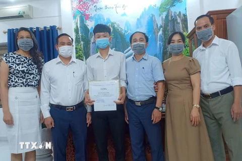 Lãnh đạo Sở Giáo dục và Đào tạo Hải Phòng chúc mừng Trần Cao Sơn đạt kết quả xuất sắc trong kỳ thi tốt nghiệp Trung học phổ thông 2021. (Ảnh: TTXVN phát)