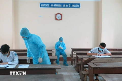 Hai thí sinh trong khu vực phong tỏa ở Phú Yên được bố trí phòng thi riêng, cán bộ coi thi mặc đồ bảo hộ. (Ảnh: Xuân Triệu/TTXVN) 
