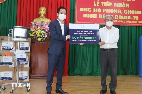 Đại diện Tập đoàn Novaland trao tượng trưng 100 máy Monitor theo dõi bệnh nhân COVID-19 cho tỉnh Đồng Nai. (Ảnh: Công Phong/TTXVN)
