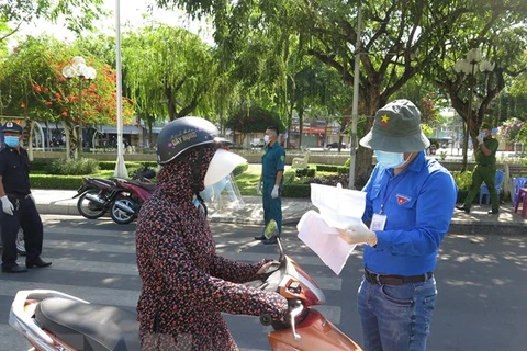 Cán bộ phòng, chống dịch ở một chốt kiểm soát thành phố Nha Trang kiểm tra giấy tờ người đi đường. (Ảnh: Phan Sáu/TTXVN) 
