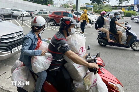Xe máy người dân chất đầy thực phẩm sau khi mua từ Trung tâm thương mại Aeon Mall Tân Phú. (Ảnh: Mạnh Linh/TTXVN) 