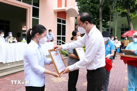 Phó Bí thư Thành ủy Thành phố Hồ Chí Minh Nguyễn Hồ Hải trao giấy biểu dương tri ân các tình nguyện viên tôn giáo đã hoàn thành nhiệm vụ. (Ảnh: Xuân Khu/TTXVN) 