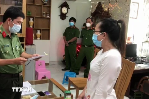 Cơ quan Cảnh sát điều tra Công an tỉnh An Giang đọc quyết định khởi tố bị can, bắt tạm giam đối với Trần Thị Thảo Trang. (Ảnh: TTXVN phát) 