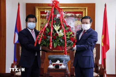 Phó Trưởng Ban Đối ngoại Trung ương Đảng Nhân dân Cách mạng Lào Somphone Sichaleun (trái) trao hoa cho Đại sứ Nguyễn Bá Hùng, chúc mừng 76 năm Quốc khánh Việt Nam. (Ảnh: Phạm Kiên/TTXVN)