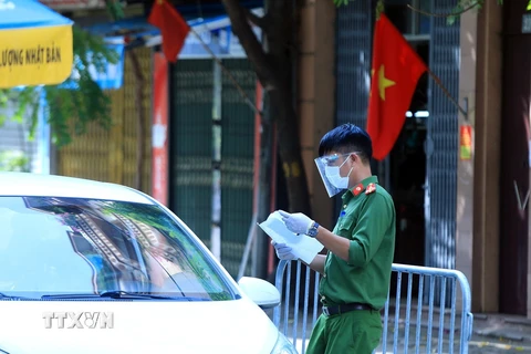 Lực lượng Công an thị trấn Phùng, huyện Đan Phượng, Hà Nội kiểm tra giấy tờ đi đường của người dân tại chốt kiểm soát dịch thị trấn trong ngày nghỉ lễ 2/9. (Ảnh: Tuấn Anh/TTXVN) 
