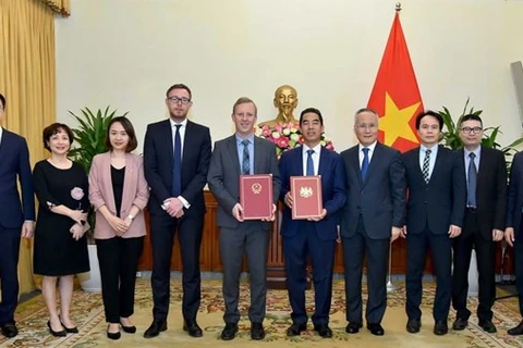 Đại diện Việt Nam và Anh trao công hàm khẳng định ngày có hiệu lực của hiệp định UKVFTA. (Ảnh: Vietnam+)
