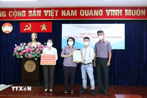 Bà Tô Thị Bích Châu, Chủ tịch Ủy ban Mặt trận Tổ quốc Việt Nam Thành phố Hồ Chí Minh tiếp nhận tượng trưng 50 máy tạo oxy do Công ty TNHH Thương mại Cao Đại Tín (HaKaWa) trao tặng. (Ảnh: Xuân Khu/TTXVN)