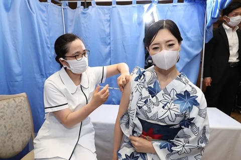 Nhân viên y tế tiêm vaccine ngừa COVID-19 cho người dân tại Tokyo, Nhật Bản. (Ảnh: AFP/TTXVN) 