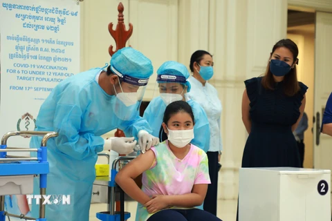 Nhân viên y tế tiêm vaccine ngừa COVID-19 cho trẻ em tại một điểm tiêm chủng ở Phnom Penh, Campuchia, ngày 17/9/2021. (Ảnh: THX/TTXVN)
