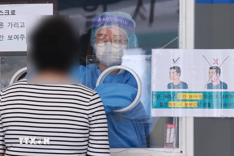 Nhân viên y tế lấy mẫu xét nghiệm COVID-19 tại Seoul, Hàn Quốc. (Ảnh: YONHAP/TTXVN)