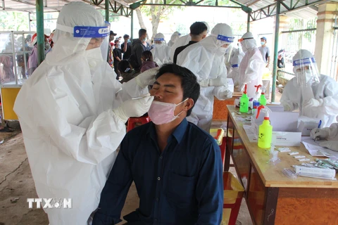 Lực lượng y tế Đắk Lắk xét nghiệm cho người dân về quê để đưa đi cách ly tập trung hoặc cho cách ly tại nhà nếu người dân đã tiêm 2 mũi vaccine. (Ảnh: Hoài Thu/TTXVN)