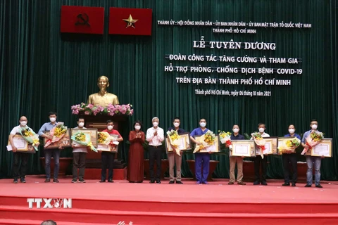 Trao Bằng khen của Chủ tịch UBND Thành phố Hồ Chí Minh cho đại diện các đoàn công tác y tế tăng cường tham gia hỗ trợ phòng, chống dịch COVID-19. (Ảnh: Xuân Khu/TTXVN)
