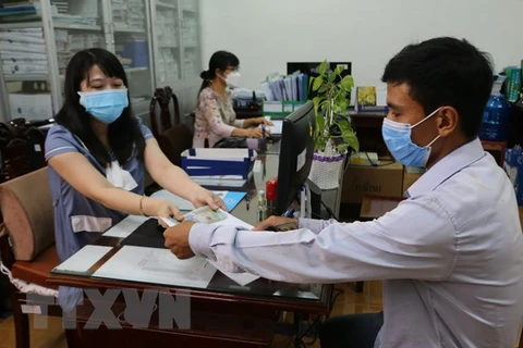 Người lao động nhận tiền hỗ trợ tại Bảo hiểm xã hội tỉnh Bạc Liêu. (Ảnh: Tuấn Kiệt/TTXVN) 