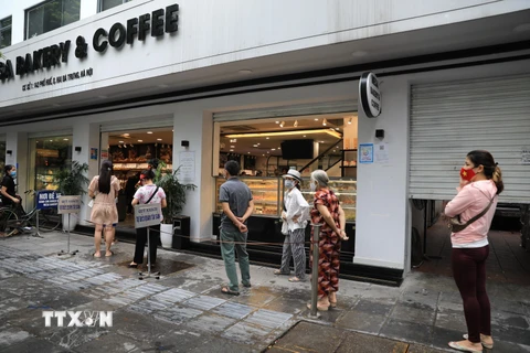 Một cửa hàng bánh trên phố Huế thực hiện nghiêm túc 5K yêu cầu khách đến mua xếp hàng đảm bảo giãn khoảng cách. (Ảnh: Tuấn Anh/TTXVN) 