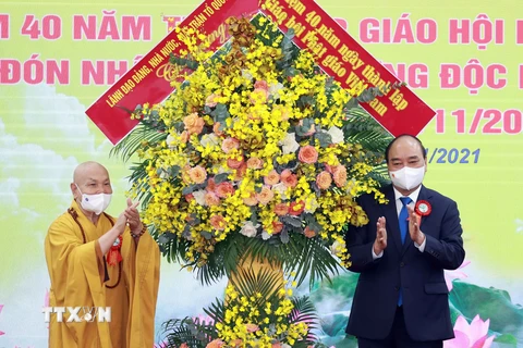Chủ tịch nước Nguyễn Xuân Phúc tặng hoa chúc mừng Giáo hội Phật giáo Việt Nam. (Ảnh: Thống Nhất/TTXVN) 