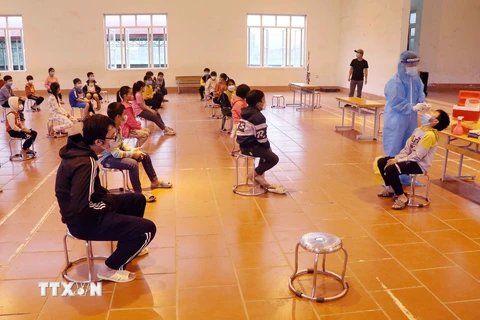 Nhân viên tế Phú Thọ tổ chức lấy mẫu xét nghiệm lần 3 cho học sinh Trường tiểu học Bạch Hạc. (Ảnh: Trung Kiên/TTXVN)