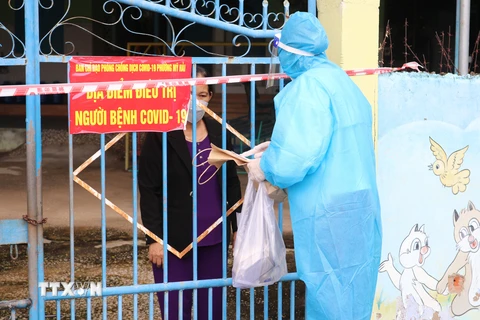 Nhân viên Trạm y tế phường Mỹ Hải, thành phố Phan Rang-Tháp Chàm đến thăm khám sức khỏe, cấp túi thuốc cho bệnh nhân mắc COVID-19 điều trị tại nhà. (Ảnh: Nguyễn Thành/TTXVN)
