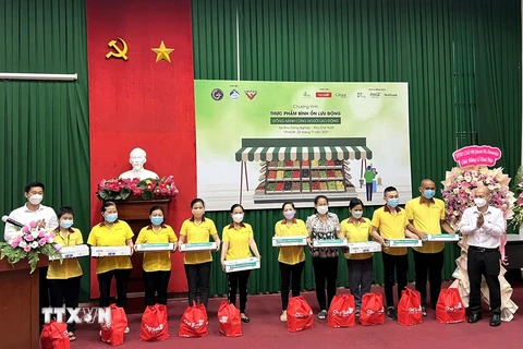 Lãnh đạo Ban Quản lý các khu chế xuất, khu công nghiệp Thành phố Hồ Chí Minh và Sở Công Thương thành phố tặng quà cho công nhân, người lao động có hoàn cảnh khó khăn. (Ảnh: TTXVN)