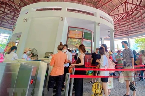 Du khách thực hiện khai báo y tế, đeo khẩu trang trước khi vào khu du lịch ở Đà Nẵng. (Ảnh: TTXVN phát)