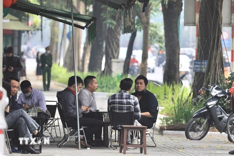 Một quán càphê trên phố Trần Hưng Đạo kinh doanh lấn chiếm vỉa hè, để khách ngồi không đảm bảo khoảng cách phòng dịch. (Ảnh: Hoàng Hiếu/TTXVN) 