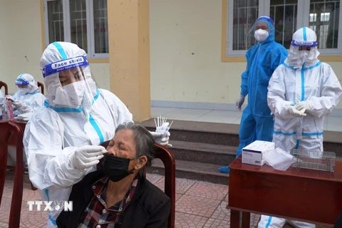 Lực lượng y tế Quảng Bình tiến hành xét nghiệm lấy mẫu sàng lọc trong cộng đồng tại khu vực liên quan đến ca bệnh F0 mới phát hiện. (Ảnh: Võ Dung/TTXVN)