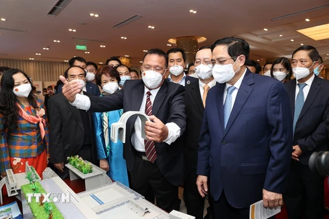 Thủ tướng Phạm Minh Chính và các đại biểu tham quan trưng bày các sản phẩm ứng dụng công nghệ sáng tạo. (Ảnh: Dương Giang/TTXVN) 