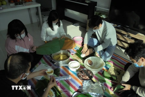 Gia đình anh Đỗ Minh Thịnh và bạn bè gói bánh chưng để chuẩn bị đón Tết. (Ảnh: Phạm Tuân/TTXVN)