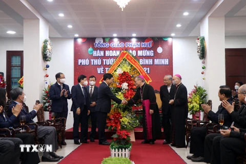 Ủy viên Bộ Chính trị, Phó Thủ tướng Thường trực Chính phủ Phạm Bình Minh tặng hoa chúc mừng Lễ Giáng sinh tại Tòa giám mục Huế. (Ảnh: Đỗ Trưởng/TTXVN)