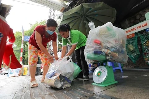 Người dân tới đổi rác tái chế lấy quà tại điểm đổi rác phường Cửa Đông, quận Hoàn Kiếm (Hà Nội). (Ảnh: Thanh Tùng/TTXVN) 