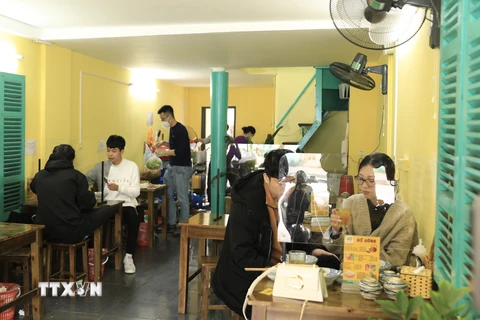 Quán bún riêu trên phố Tôn Thất Tùng được trang bị đầy đủ vách ngăn đảm bảo phòng dịch cho thực khách. (Ảnh: Hoàng Hiếu/TTXVN) 