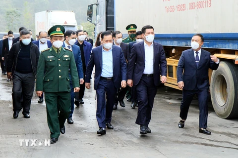 Bộ trưởng Bộ Công thương Nguyễn Hồng Diên đi kiểm tra thực tế tại bãi xe chờ xuất khẩu hàng hóa. (Ảnh: Thế Anh/TTXVN)
