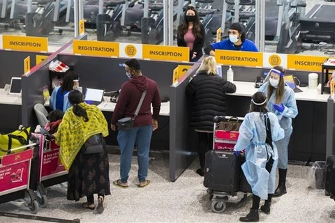 Hành khách đeo khẩu trang phòng lây nhiễm COVID-19 tại sân bay quốc tế Toronto ở Mississauga, Ontario (Canada). (Ảnh: THX/TTXVN) 