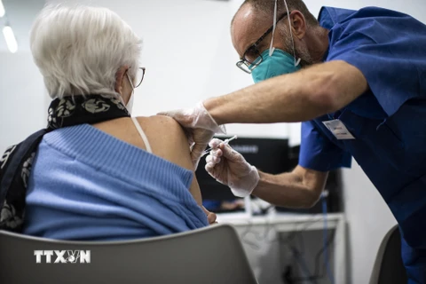 Nhân viên y tế tiêm vaccine ngừa COVID-19 cho người dân tại Turin, Italy. (Ảnh: AFP/TTXVN)