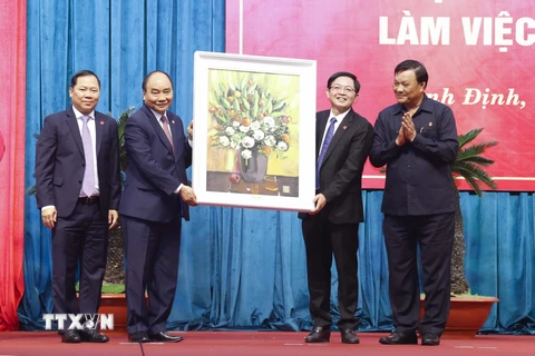 Chủ tịch nước Nguyễn Xuân Phúc tặng bức tranh lưu niệm cho tỉnh Bình Định. (Ảnh: Thống Nhất/TTXVN) 