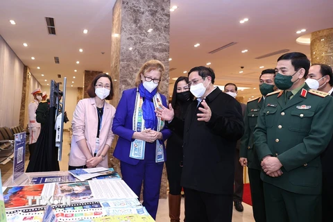 Thủ tướng Phạm Minh Chính tham quan trưng bày ảnh, sách, báo, tuyên truyền về phòng tránh bom mìn. (Ảnh: Dương Giang/TTXVN) 