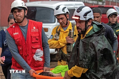 Lực lượng cứu hộ chuyển nạn nhân tại hiện trường vụ sạt lở đất do mưa lớn ở thành phố cổ Petropolis, Đông Nam Brazil, ngày 18/2/2022. (Nguồn: AFP/TTXVN) 