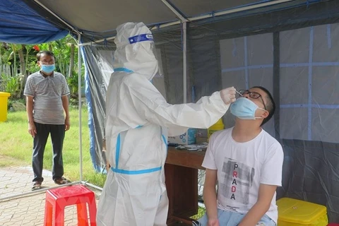 Nhân viên tại Trạm y tế lưu động xét nghiệm SARS-CoV-2 cho người dân. (Ảnh: TTXVN) 