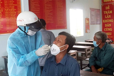 Nhân viên y tế lấy mẫu xét nghiệm COVID-19 tại Cà Mau. (Ảnh: Huỳnh Anh/TTXVN) 