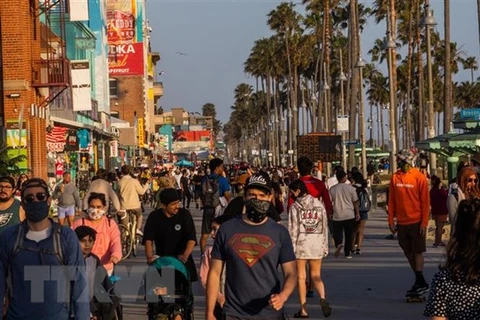 Người dân đi dạo trên bãi biển ở Mỹ. (Ảnh: AFP/TTXVN)