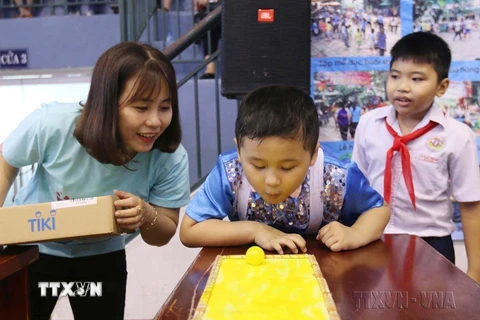 Nhân viên Mạng lưới tự kỷ Việt Nam hướng dẫn trẻ tự kỷ tham gia các trò chơi thực hành hòa nhập cộng đồng tại Ngày hội tri ân giáo viên trẻ tự kỷ (16/11/2019). (Ảnh: Thanh Vũ/TTXVN) 