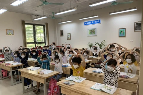 Học sinh lớp 2A1 trường Tiểu học Hoàng Mai trong tiết học đầu tiên tại trường. (Ảnh: PV/Vietnam+) 