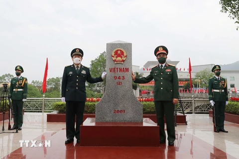 Bộ trưởng Quốc phòng Phan Văn Giang và Bộ trưởng Quốc phòng Trung Quốc Ngụy Phượng Hòa bên cột mốc biên giới Việt Nam tại cửa khẩu Tà Lùng. (Ảnh: Trọng Đức/TTXVN)