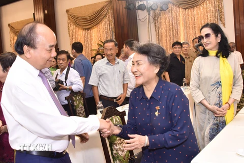 Chủ tịch nước Nguyễn Xuân Phúc giao lưu cùng các đại biểu tại buổi họp mặt. (Ảnh: Thu Hương/TTXVN) 
