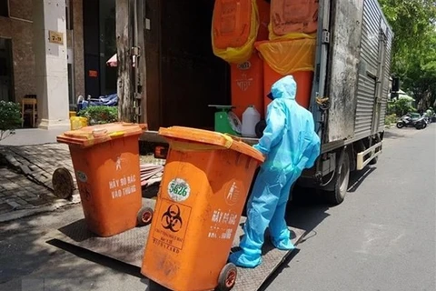 Công nhân vệ sinh thu gom, vận chuyển chất thải phòng chống dịch COVID-19. (Ảnh: Hồng Giang/TTXVN)
