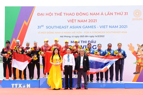 Ban tổ chức trao huy chương cho các đội nội dung thuyền 4 nữ hạng nặng chèo đơn (W4-), gồm Việt Nam (giữa - huy chương Vàng), Indonesia (trái - huy chương Bạc) và Thái Lan (phải - huy chương Đồng). (Ảnh: Minh Đức/TTXVN)
