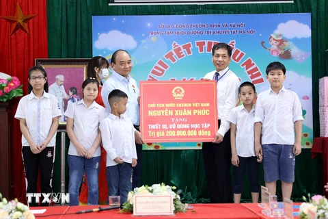 Chủ tịch nước Nguyễn Xuân Phúc tặng quà cho Trung tâm Nuôi dưỡng trẻ khuyết tật Hà Nội. (Ảnh An Đăng/TTXVN) 