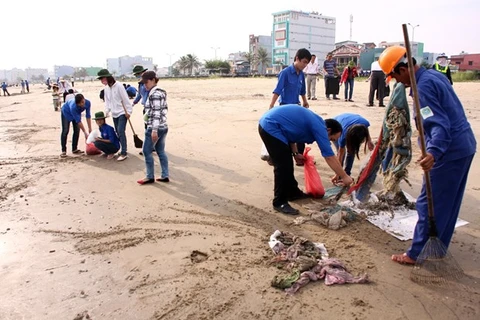 Đoàn viên thanh niên dọn vệ sinh môi trường tại bãi biển Nguyễn Tất Thành ( Đà Nẵng). (Ảnh: Trần Lê Lâm/TTXVN) 