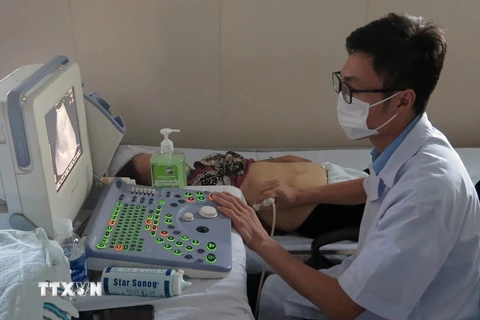 Bác sỹ trên tàu bệnh viện Khánh Hòa 01 siêu âm cho bệnh nhân. (Ảnh: Xuân Triệu/TTXVN) 