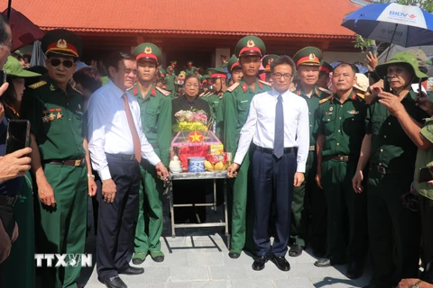 Nguyên Chủ tịch nước Trương Tấn Sang, Phó Thủ tướng Vũ Đức Đam cùng các đại biểu thực hiện nghi thức an táng hài cốt các liệt sỹ về với đồng đội. (Ảnh: Minh Tâm/TTXVN)